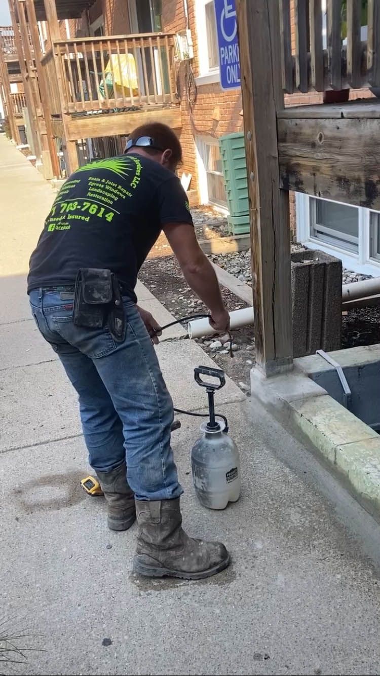 A man is spraying a pipe with a spray bottle on the sidewalk.