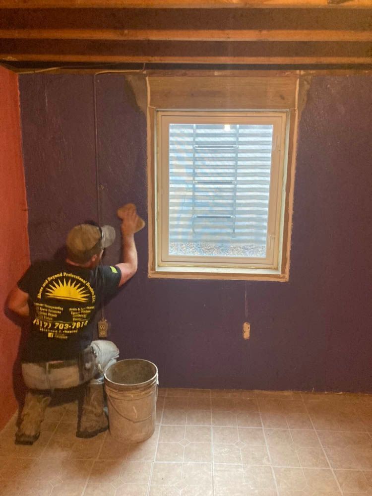 A man is kneeling down in front of a window in a room.