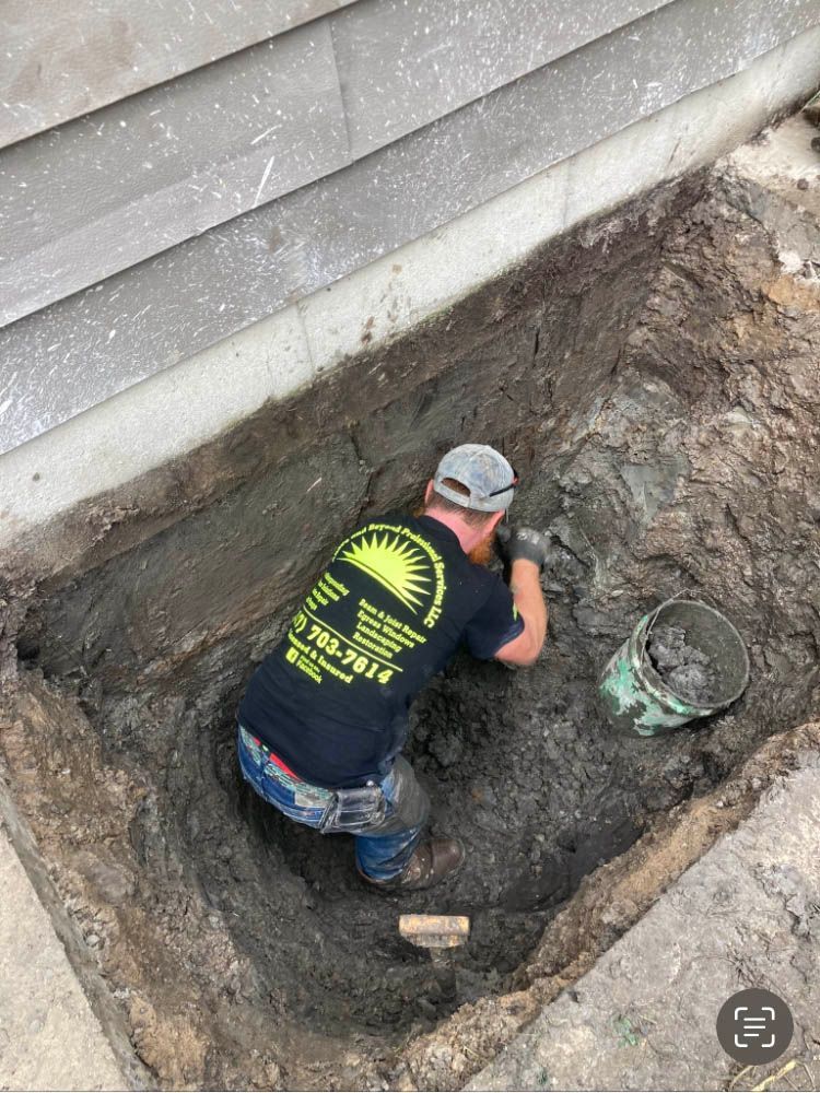 A man is kneeling down in a hole in the ground.