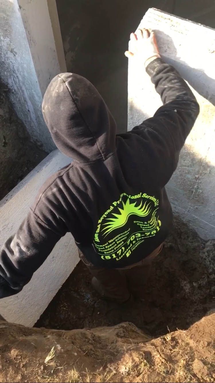 A person wearing a black hoodie is standing in the dirt.