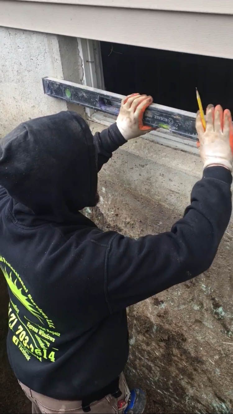 A person is measuring a window with a level.