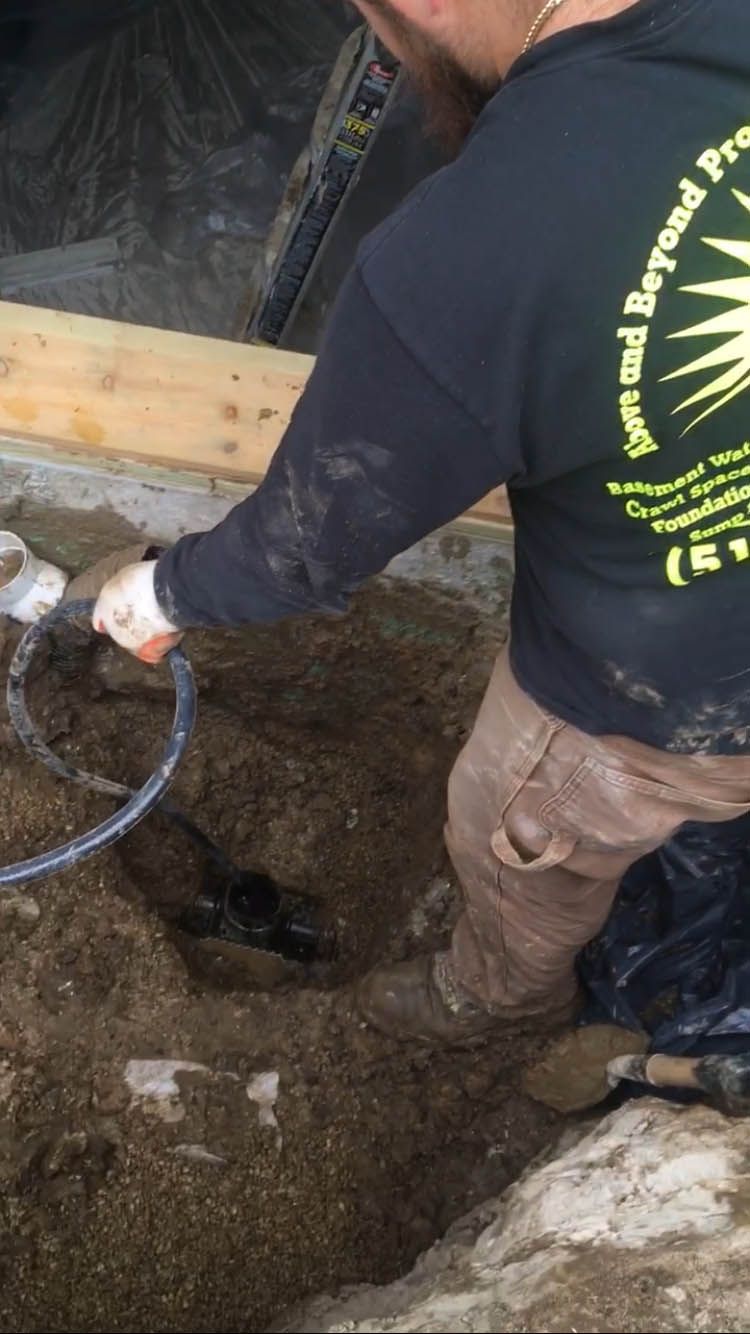 A man in a black shirt is digging a hole in the ground.