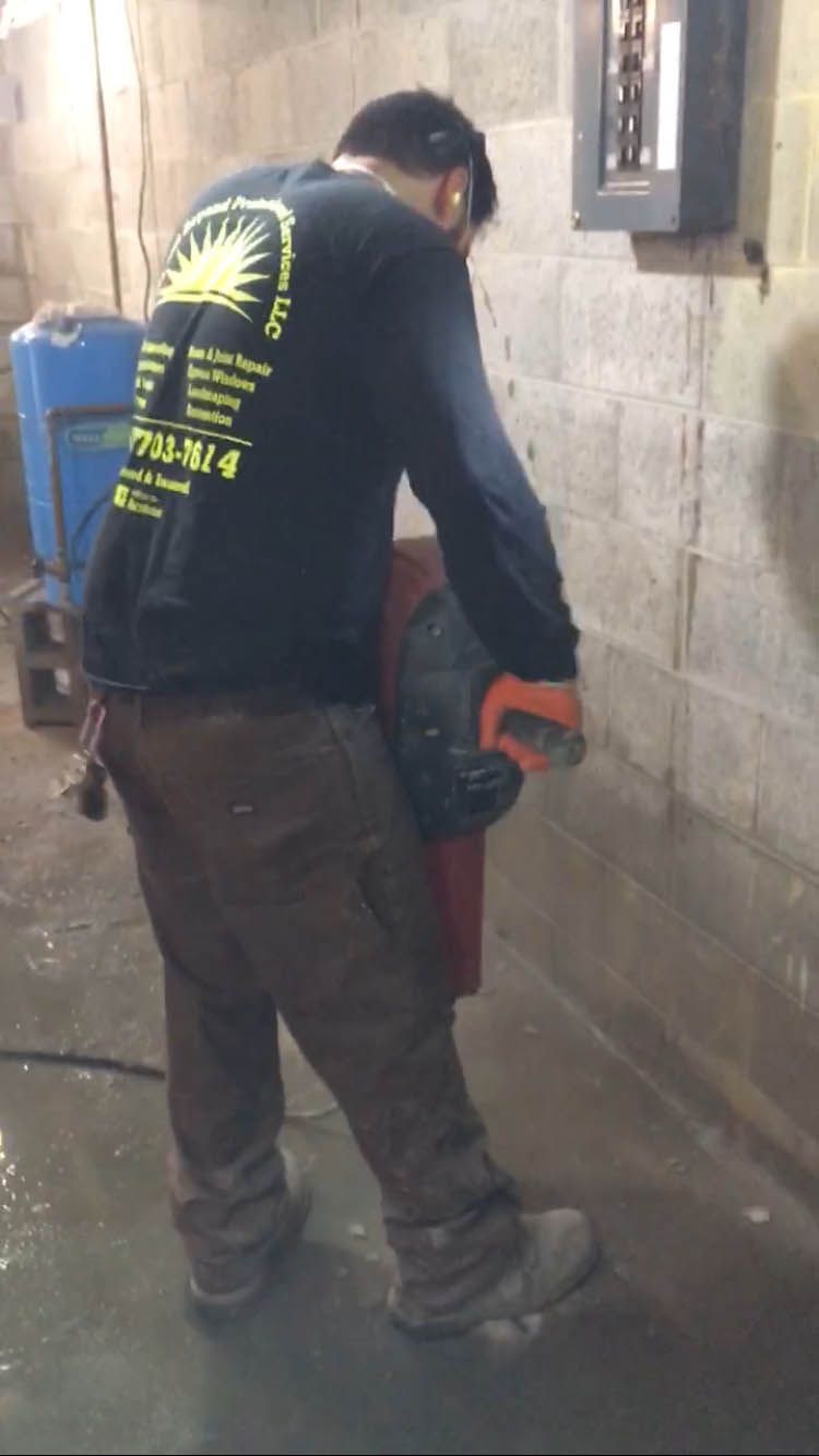 A man is standing in a basement holding a drill.