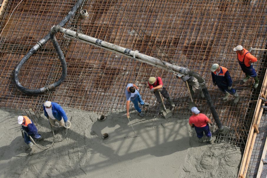A Group Of Construction Workers Are Working On A Concrete Floor — Twin Towns Sand & Gravel In Byron Bay, NSW