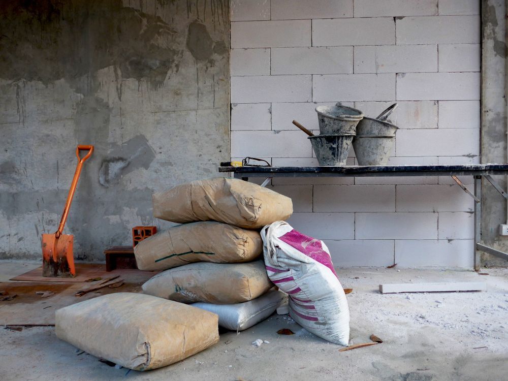A Bags of Cement Are Stacked on Top of Each Other in a Room Under Construction — Twin Towns Sand & Gravel In Byron Bay, NSW