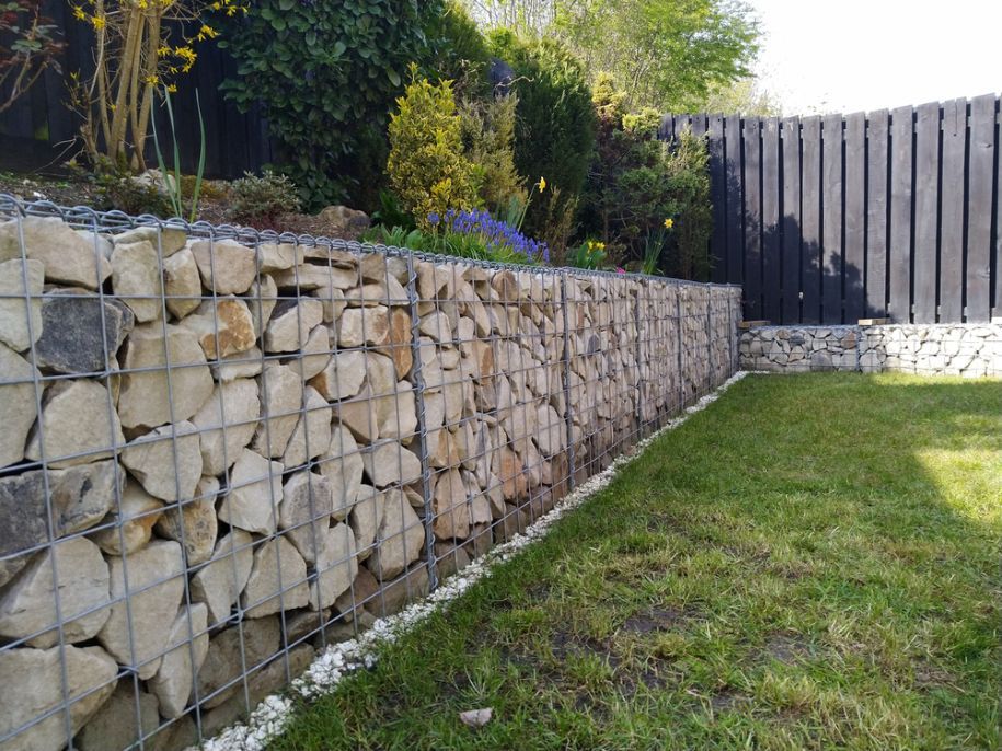 A Stone Wall Surrounds A Lush Green Lawn In A Backyard — Twin Towns Sand & Gravel In Tweed Heads South, NSW