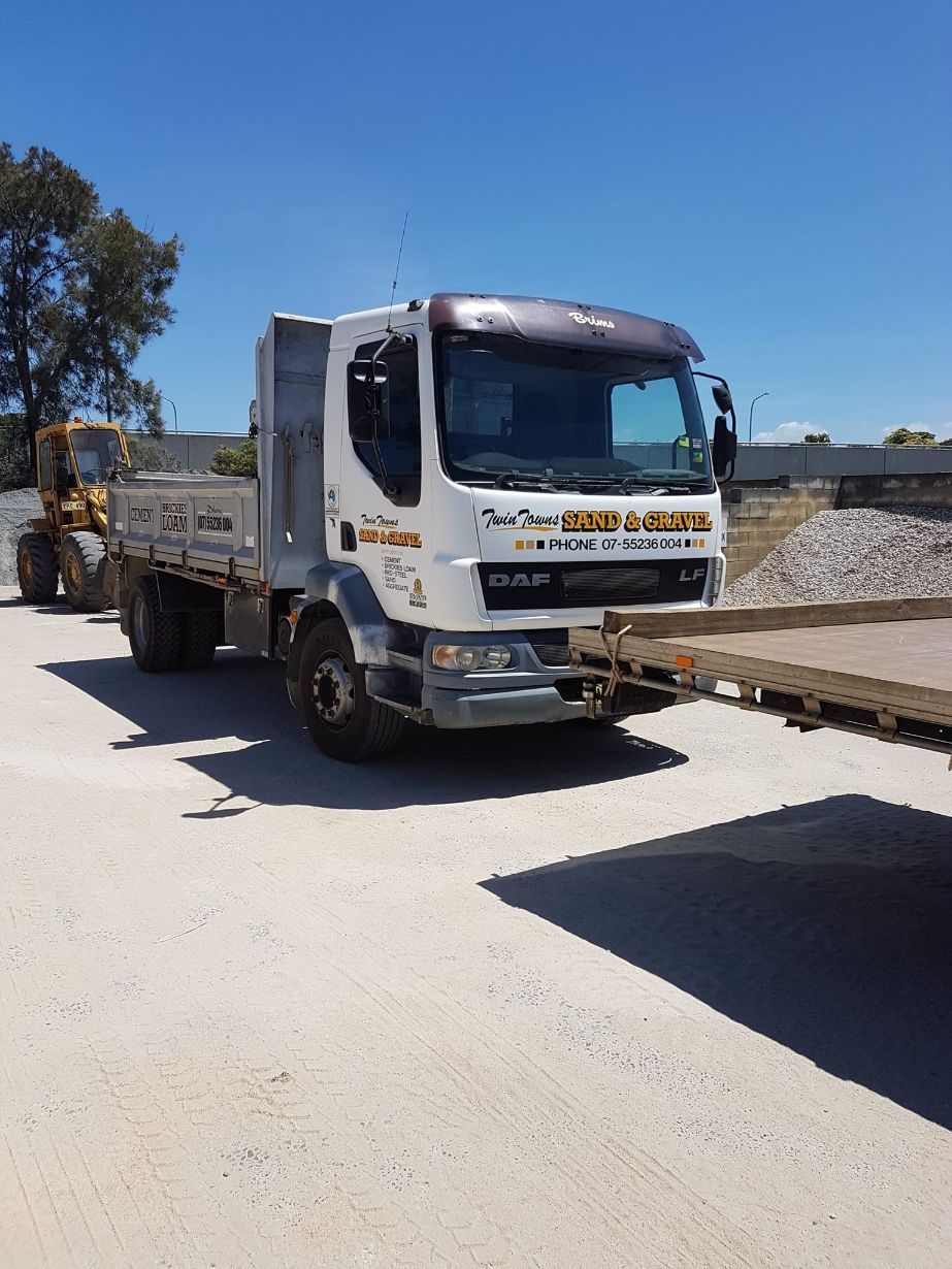 A Dump Truck Is Parked On The Side Of The Road Next To A Bulldozer — Twin Towns Sand & Gravel In Tweed Heads South, NSW