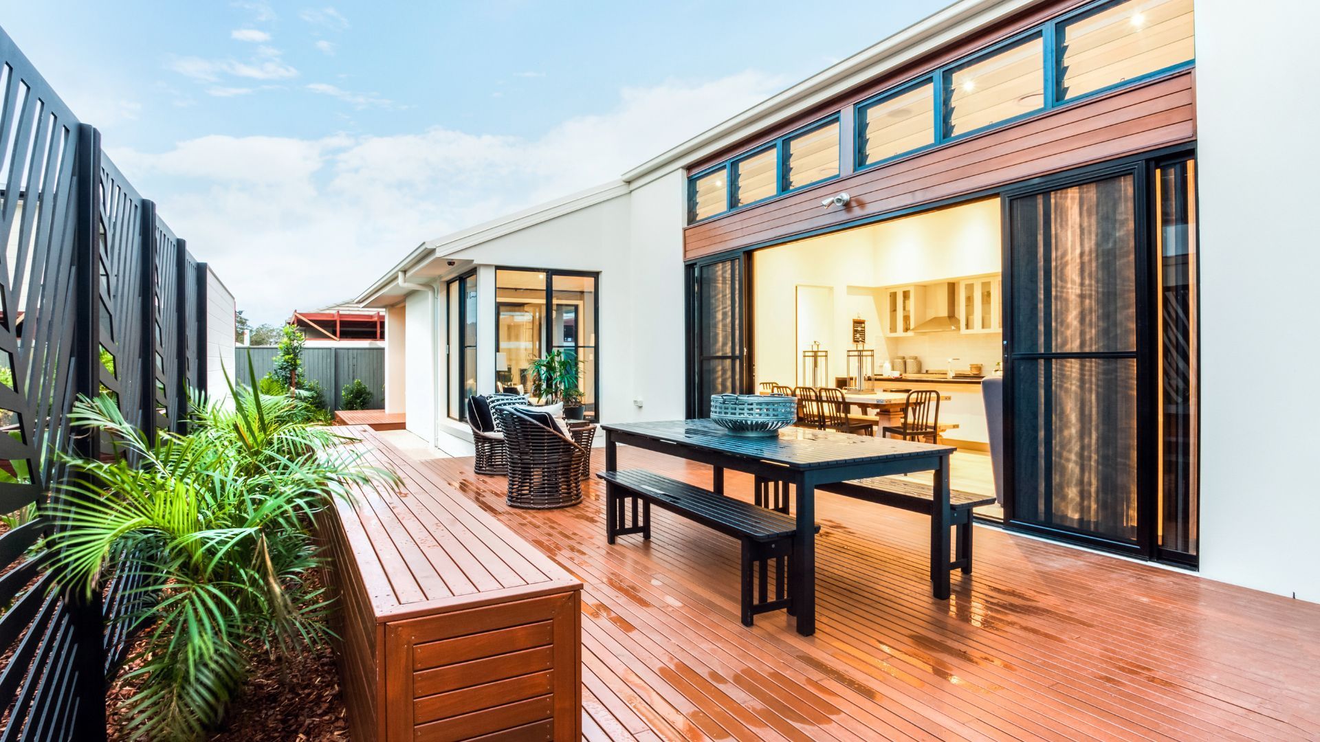 Modern deck in Chula Vista, CA with dining area, seating, planter boxes, and large sliding glass doo