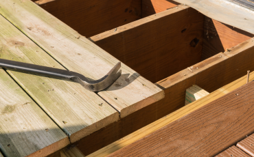 A photo of a deck in the process of being repaired. The deck had olf rotted wood and is being replaced with long-lasting composite decking materials.