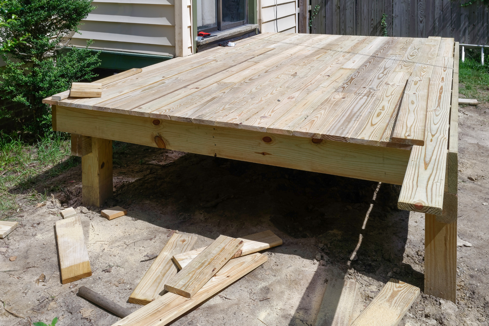 A photo of a small deck in the process of being built. South Bay Deck Pros is building this deck. All that is left is to install a railing and steps leading up the deck.