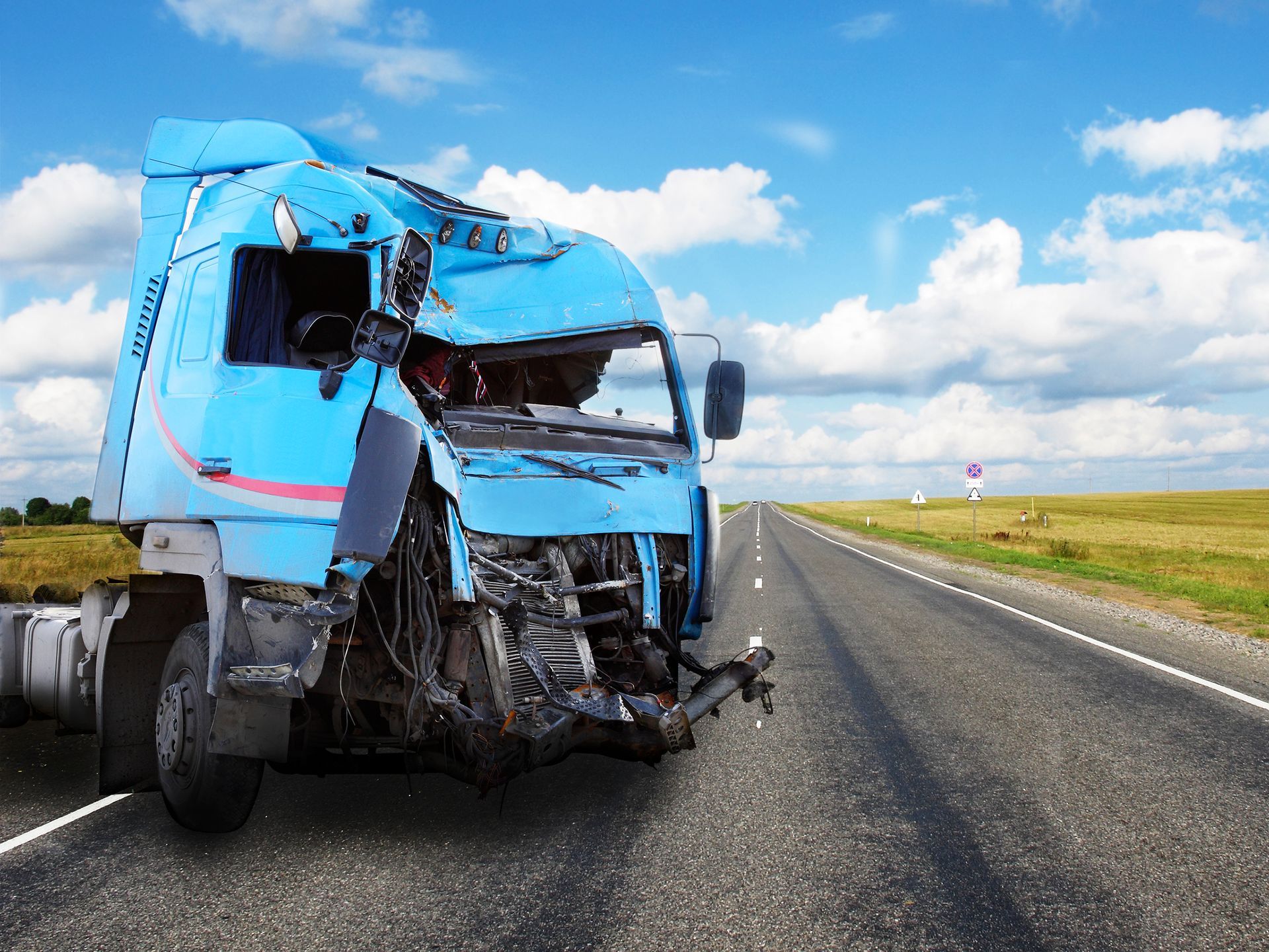Wrecked truck accident scene showing damaged vehicle and debris on the road.
