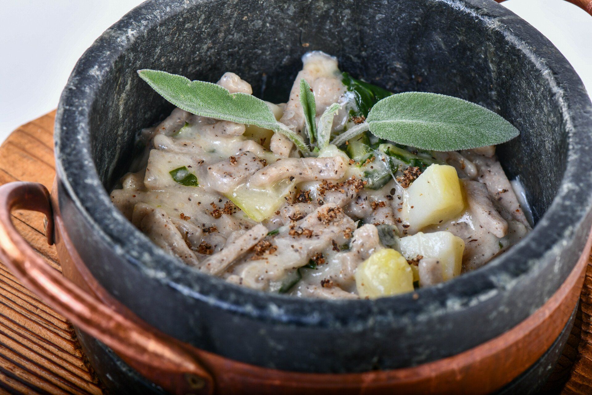 Una pentola di cibo è su un tagliere accanto a una pianta