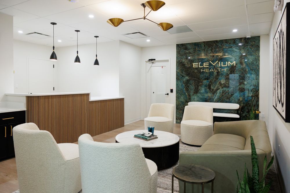 A living room with a couch , chairs , and a table.