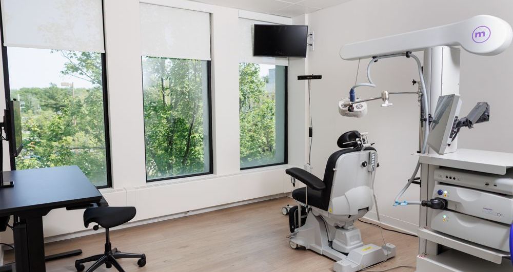 There is a dental chair in the middle of the room.