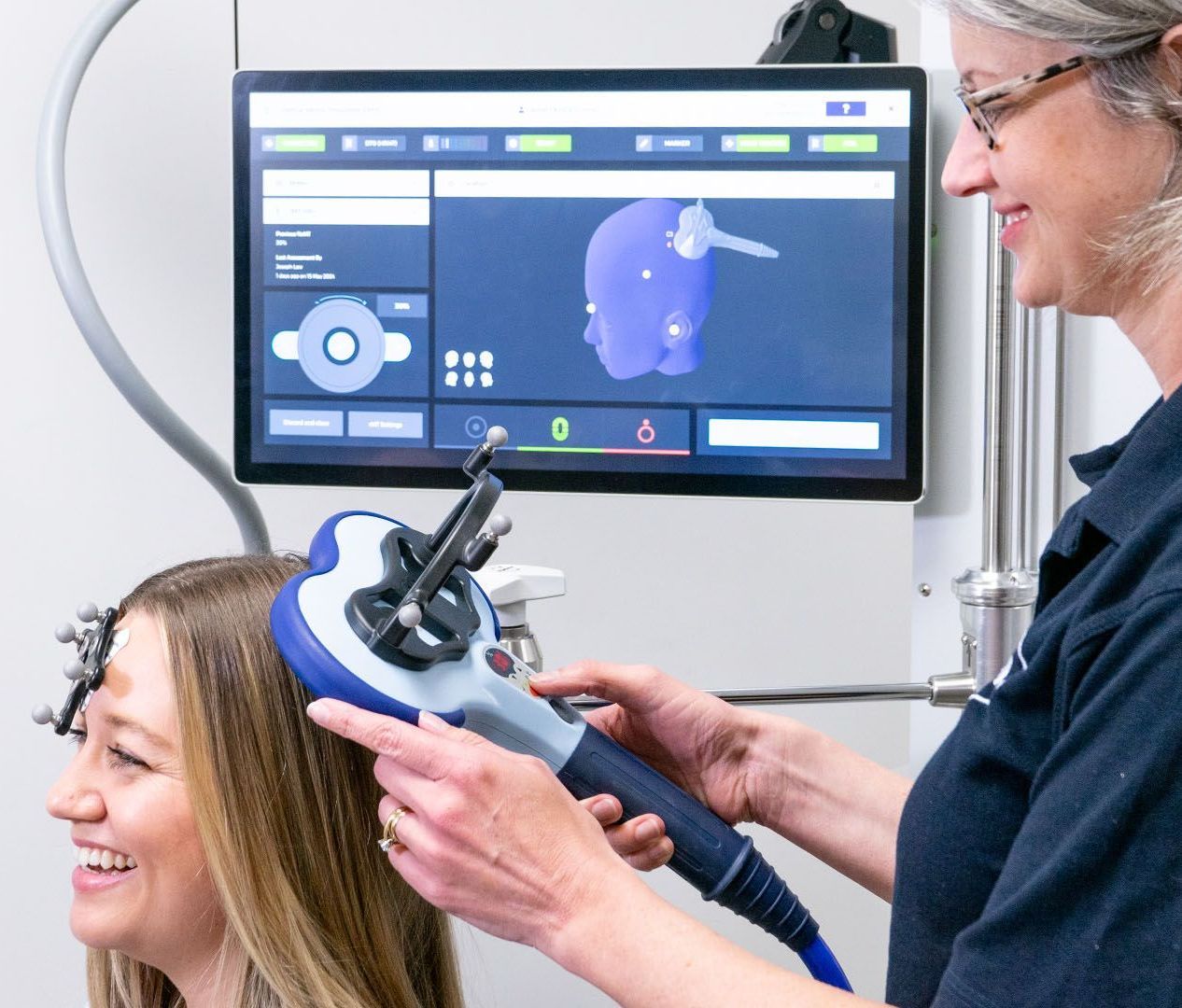 A woman is smiling while being treated by a doctor