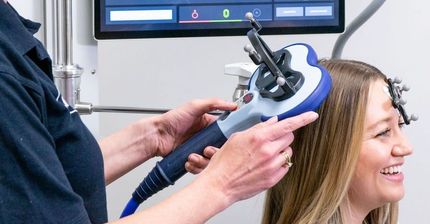 A woman is getting a hair treatment with a machine.