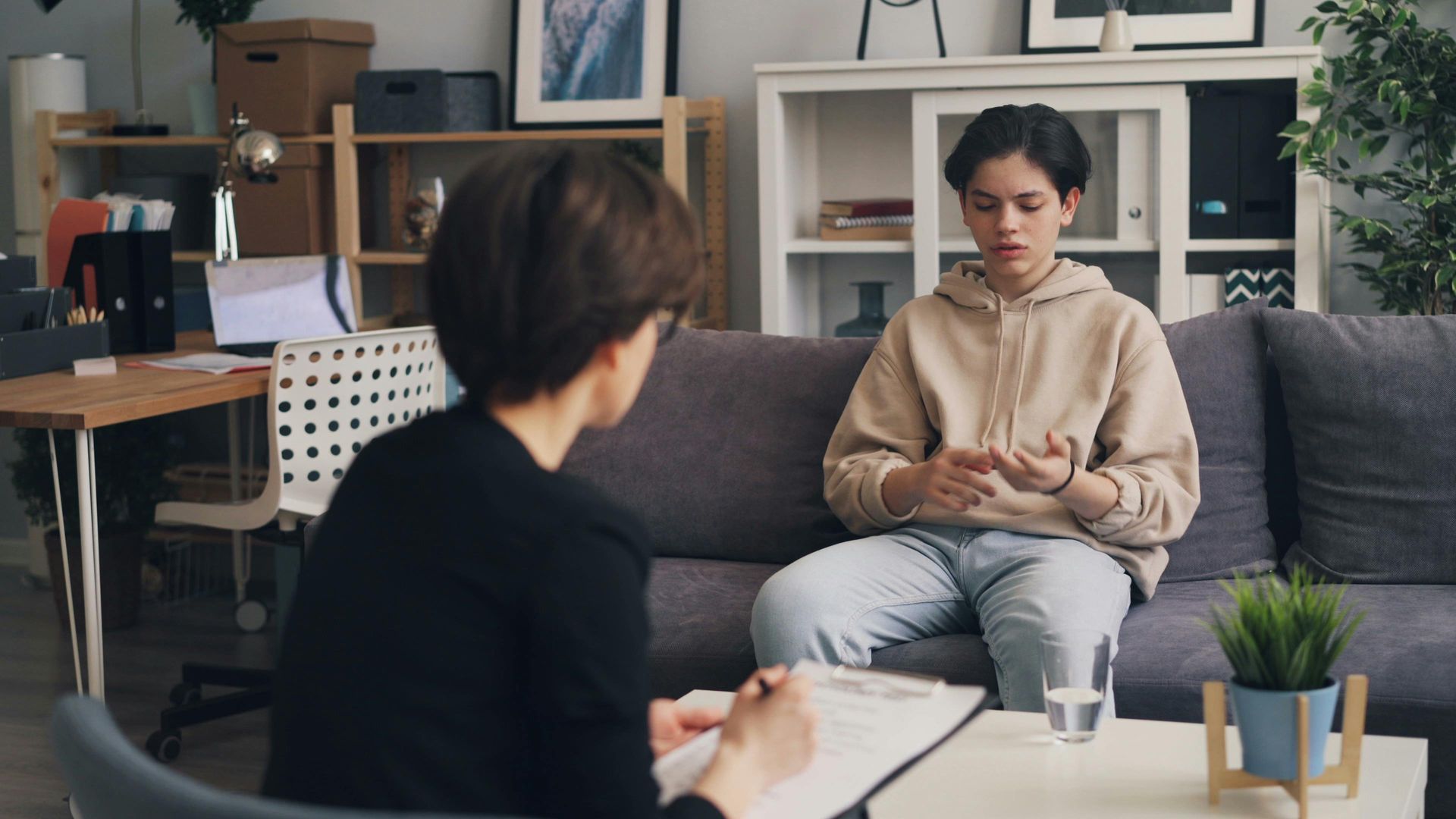 Counselor and client in a therapy office, seated across from each other during a conversation.