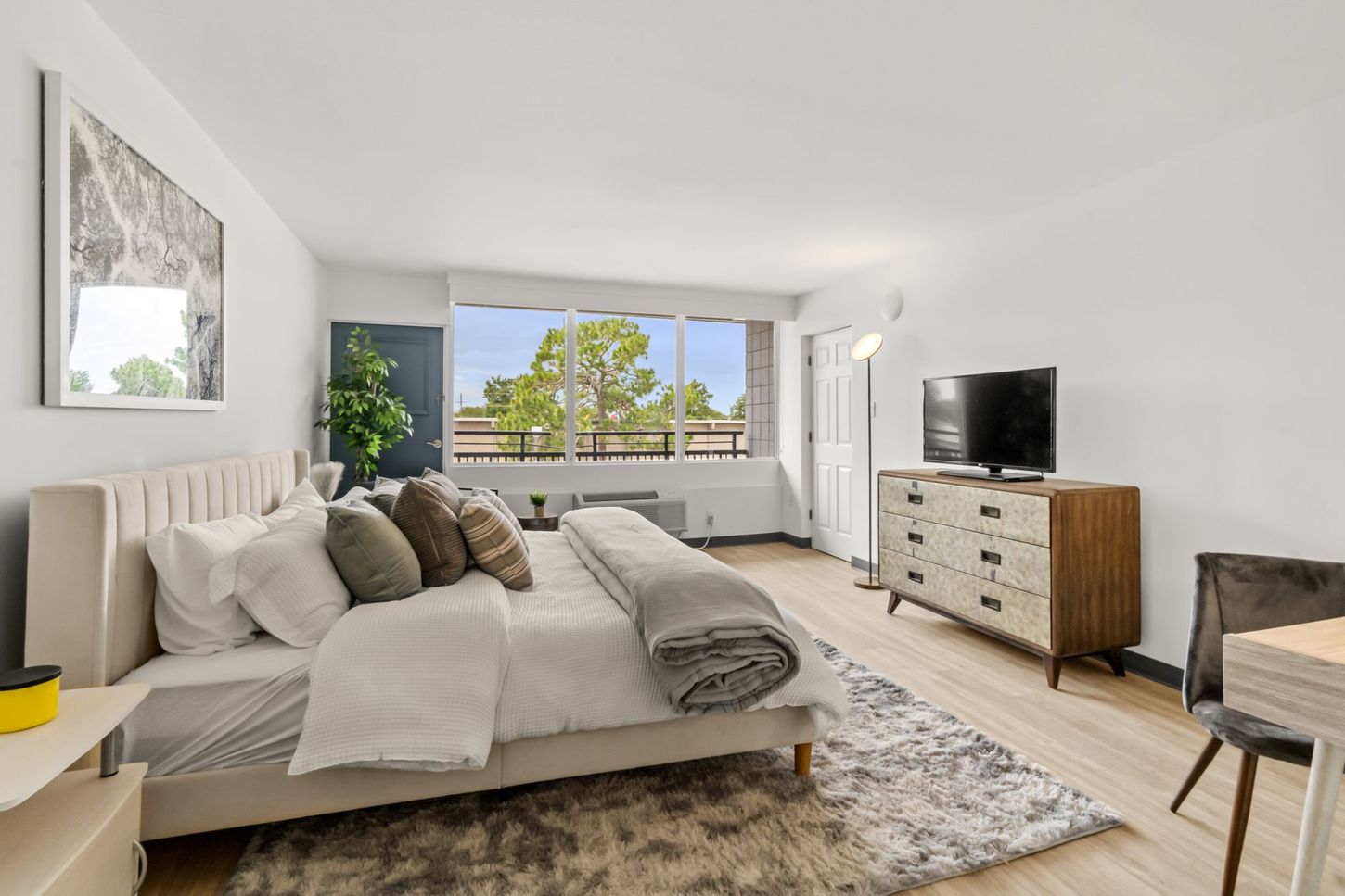 A bedroom with a bed , dresser , and television.