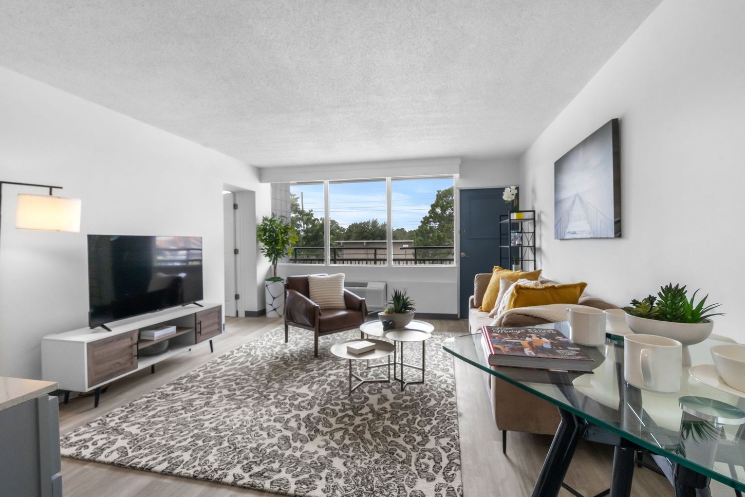 A living room with a couch , chair , table and television.