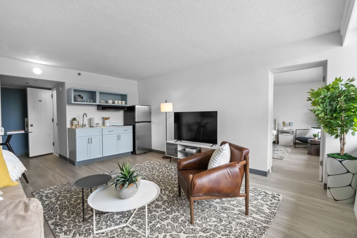 A living room with a couch , chair , table and television.