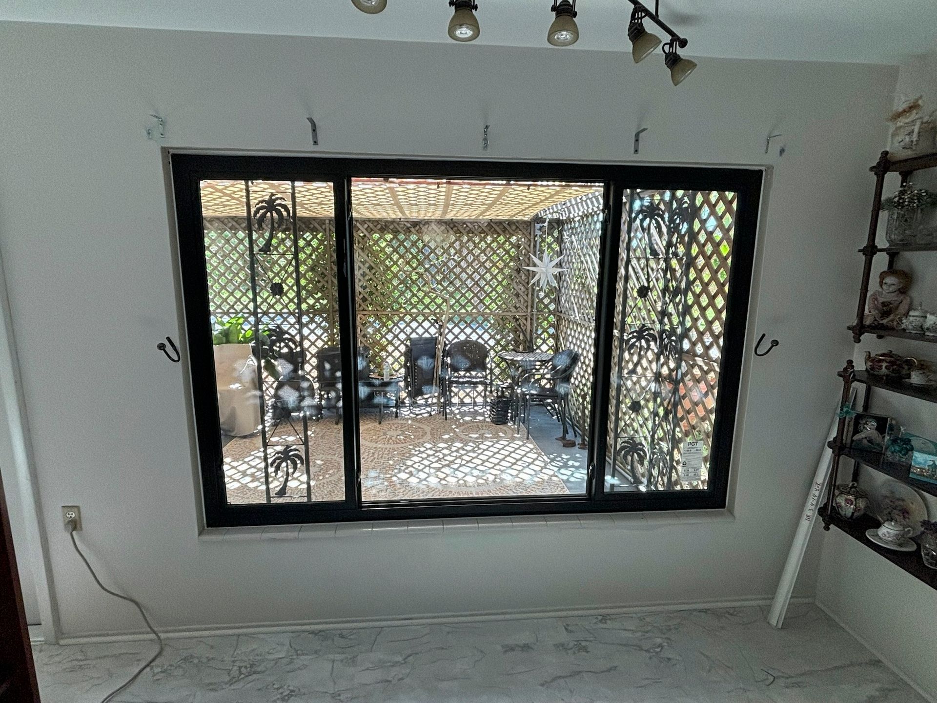 Black-framed window with decorative metal grilles.