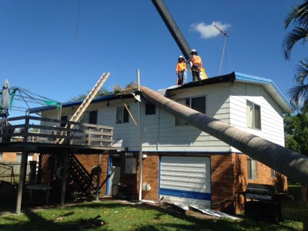 Two Men Are Working on The Roof of A House — Troy Weier Tree Service In Frenchville, QLD