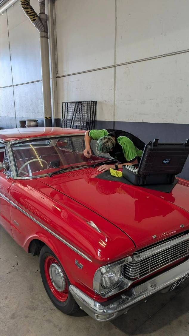 A Man is Working on a Red Car in a Garage — High Grade Tyre and Mechanical in Toowoomba City, QLD