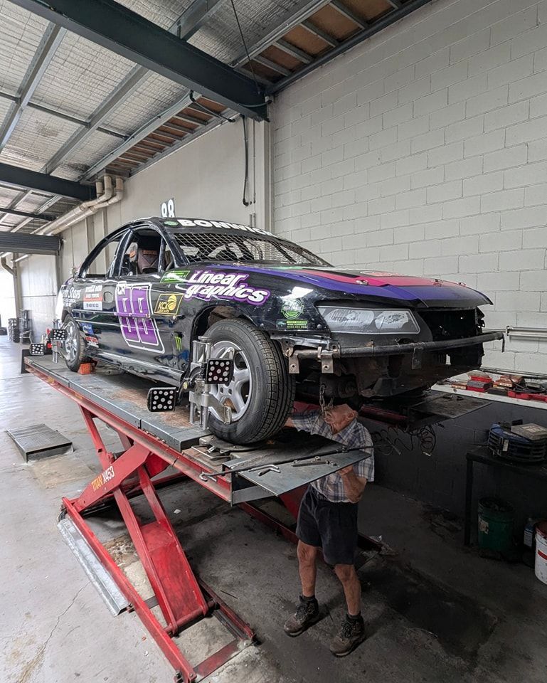 A Man working on a lifted Race Car — High Grade Tyre and Mechanical in Toowoomba City, QLD