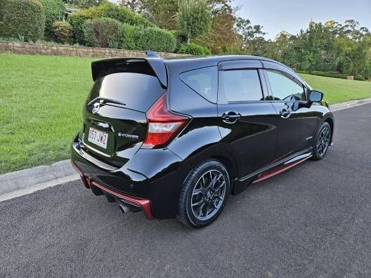 A Black Car is Parked on the Side of the Road Next to a Grassy Field — High Grade Tyre and Mechanical in Toowoomba City, QLD