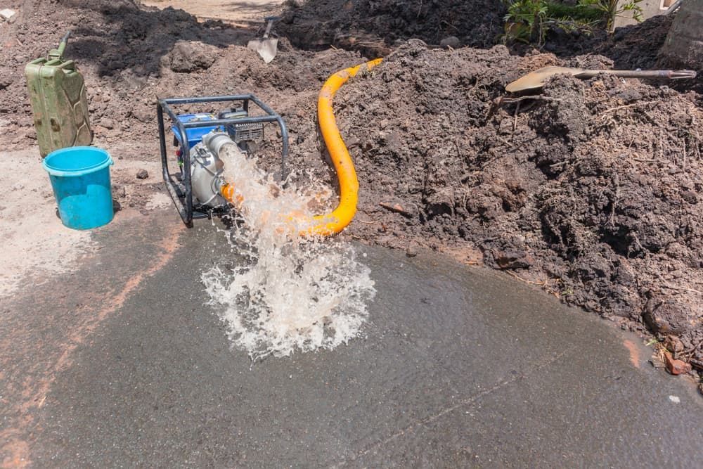 A Blue Water Pump Expels Water Through an Orange Hose