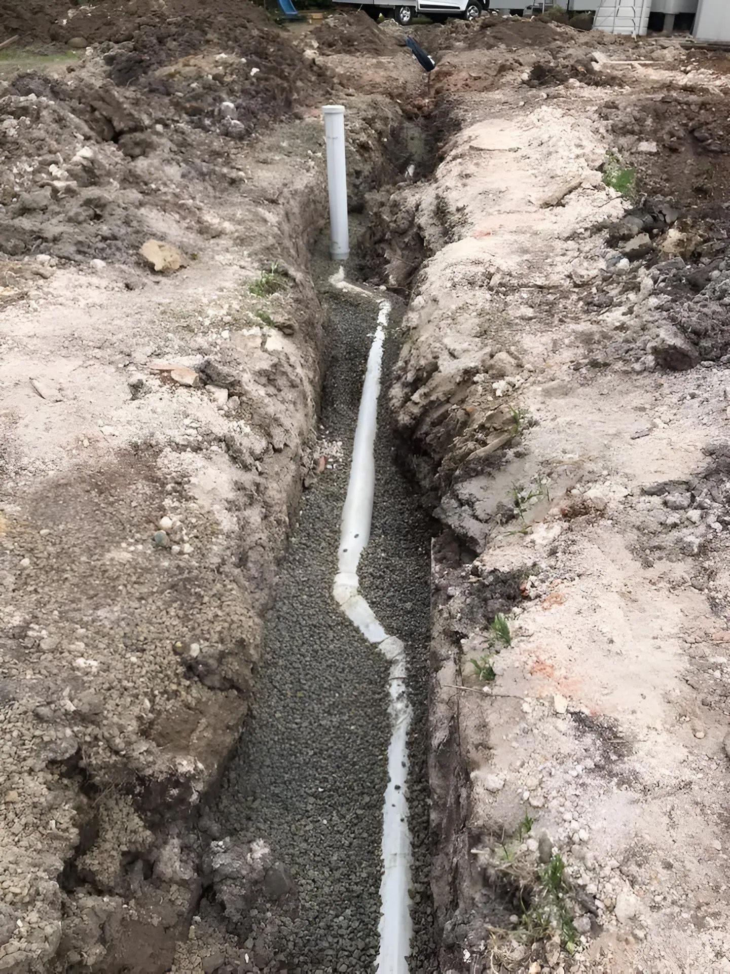 Trench Filled with Gravel and White Pipe — Richardson Plumbing & Gas Service In Port Macquarie, NSW