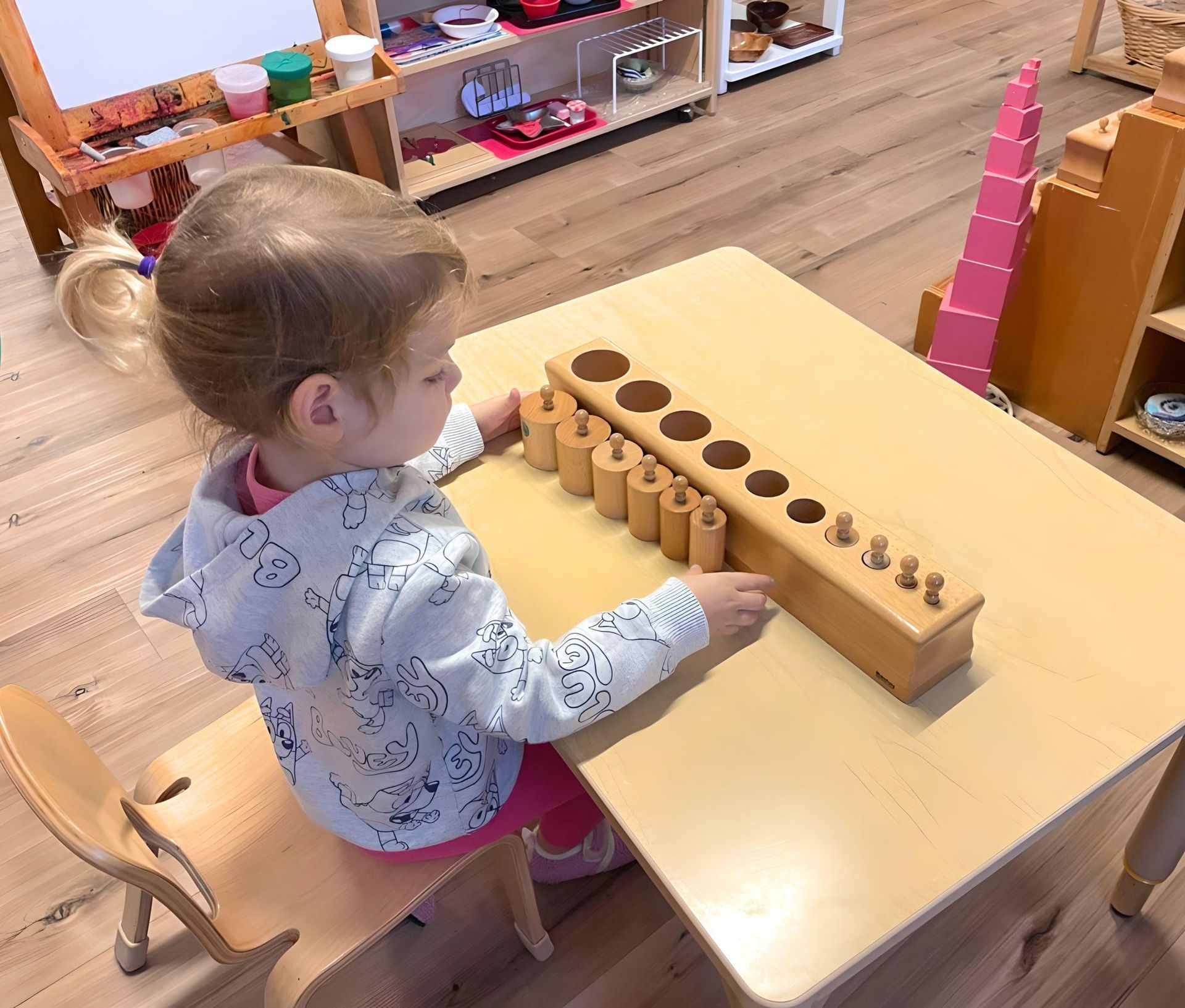 Child working with the Montessori knobbed cylinders material