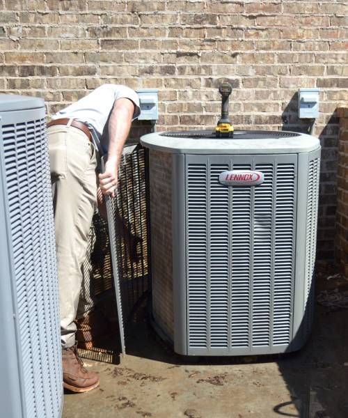 A man is installing an air conditioner on a wall