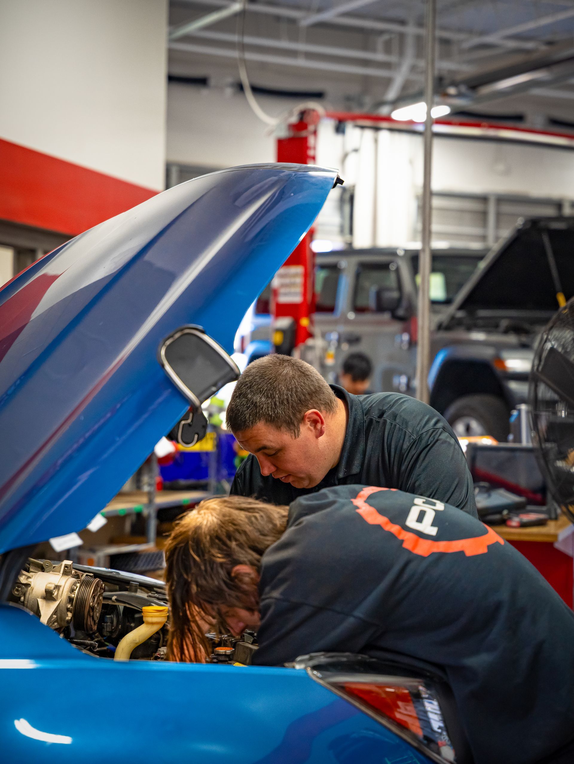 Technicians at Paul Campanella’s Auto Centers diagnosing a vehicle under the hood in a professional 