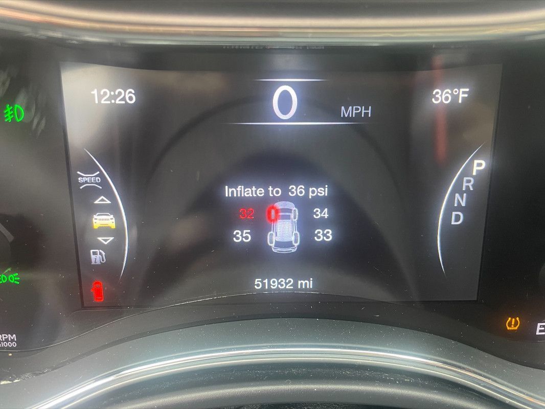 A close up of the dashboard of a car showing the tire pressure.