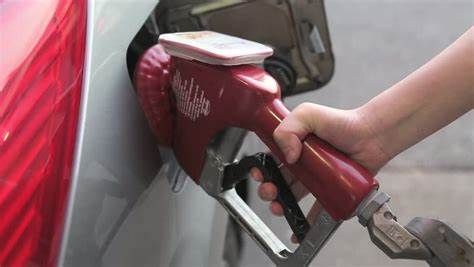 A person is pumping gas into a car at a gas station. | Paul Campanella's Auto Centers