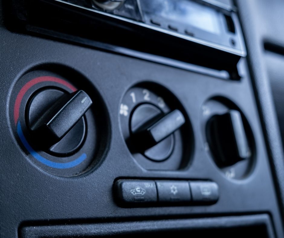 Car's dashboard with climate controls: temperature, fan speed, vents, and stereo.