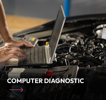 Mechanic uses laptop for computer diagnostic on car engine.