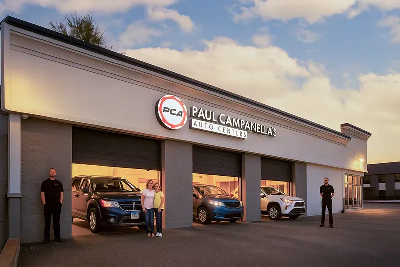 A couple of people standing in front of a car dealership. | Paul Campanella's Auto Centers