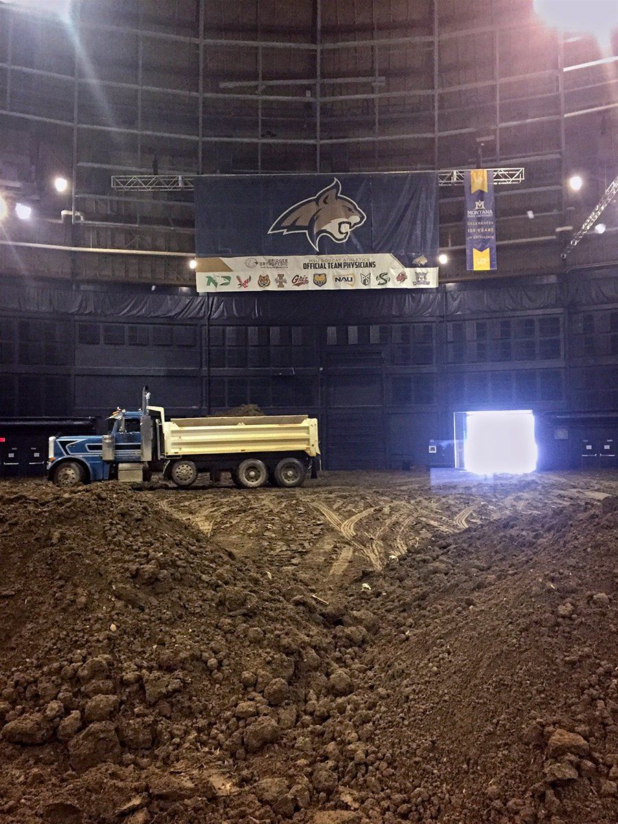 A dump truck is parked in front of a large building