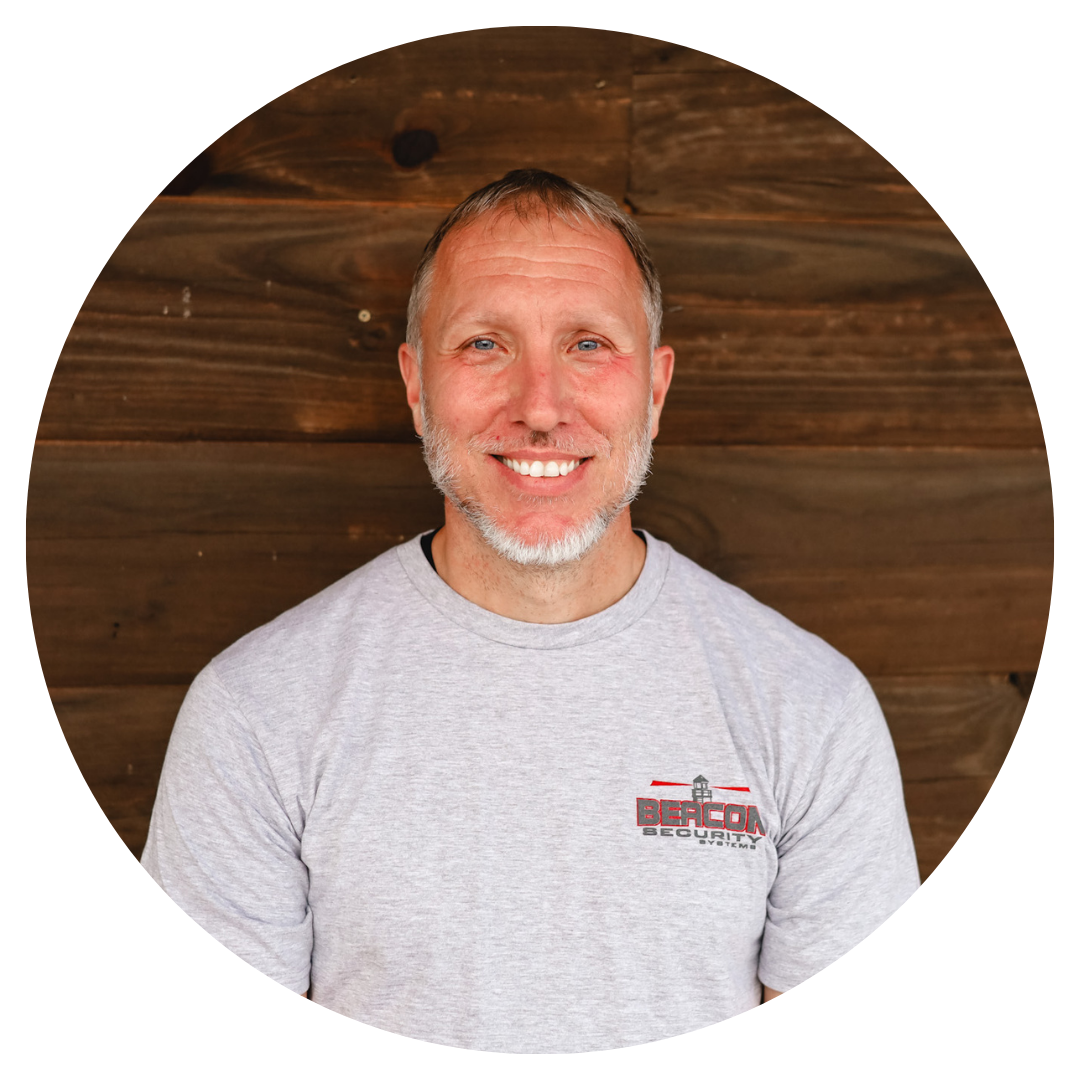 a man wearing a beacon t-shirt smiles for the camera