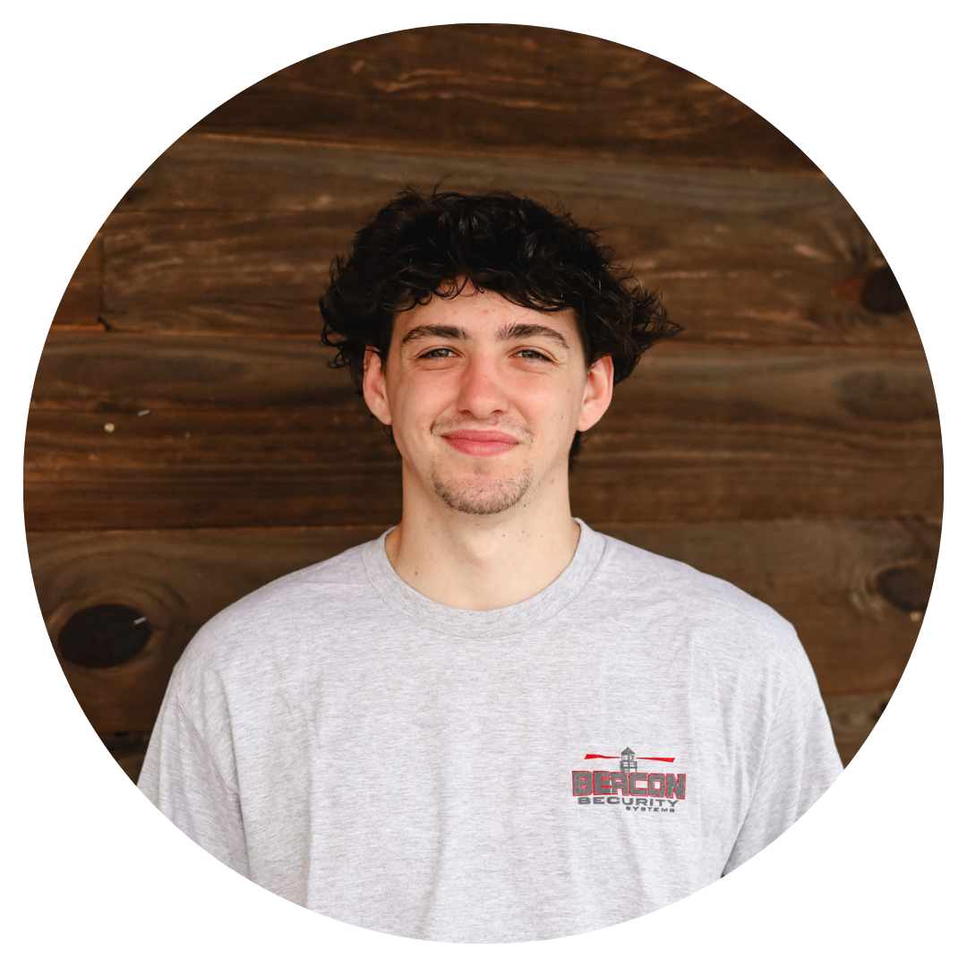 a man wearing a beacon t-shirt smiles for the camera