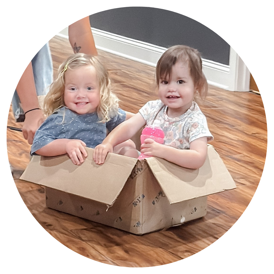 Two babies are sitting in a chair in front of a beacon security systems sign