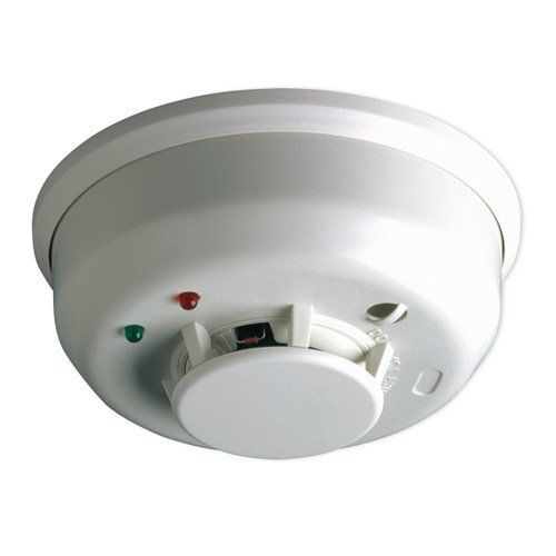 A white smoke detector with red and green lights on it