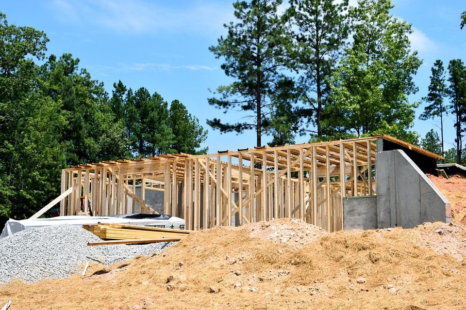 A house is being built on a hill with trees in the background
