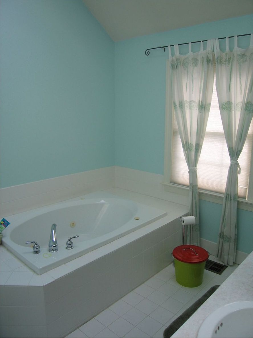 A bathroom with a jacuzzi tub and a window