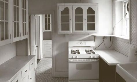 A black and white photo of a kitchen with a stove and sink