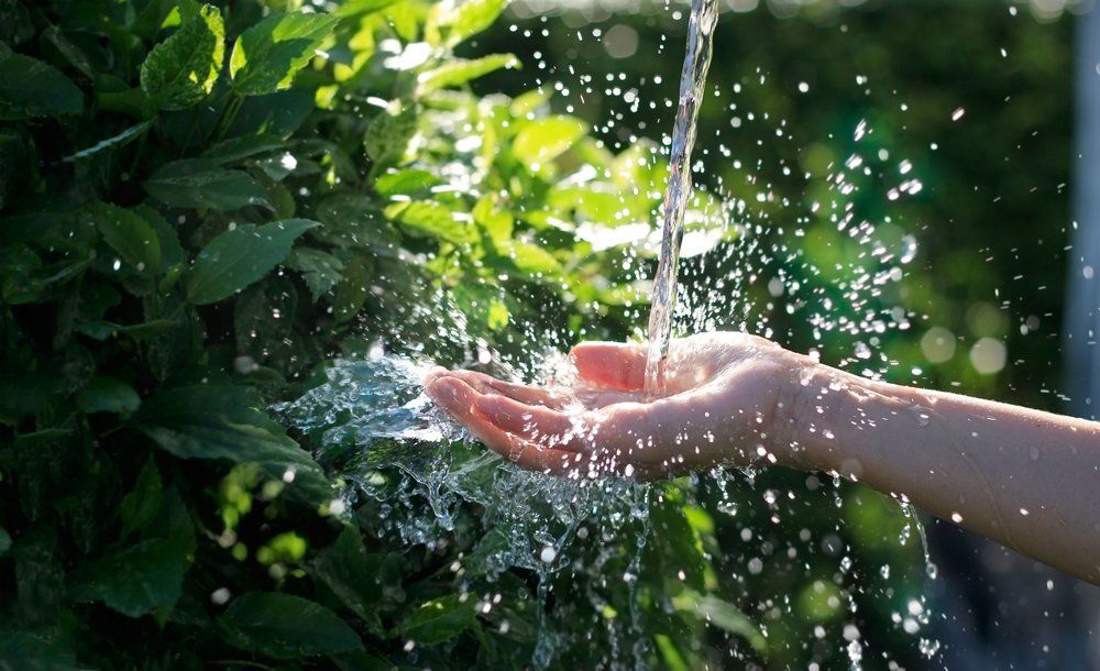 Water Treatment — Water Pouring in Woman's Hand in Bainbridge Island, WA