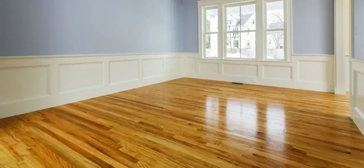 An empty room with hardwood floors and blue walls.