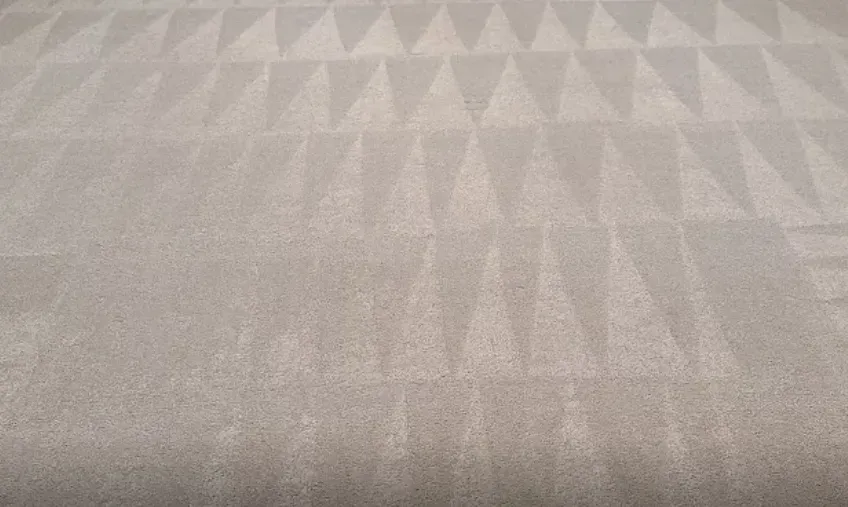 A close up of a carpet with a pattern of triangles on it.